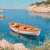 Ruhiges Meer mit einem Boot und Blumen am Ufer Puzzle